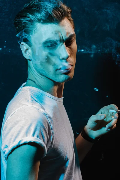 Handsome young man smoking cigarette — Stock Photo, Image