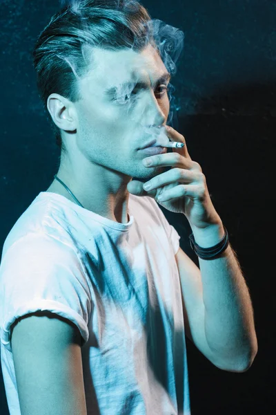 Handsome young man smoking cigarette — Stock Photo, Image