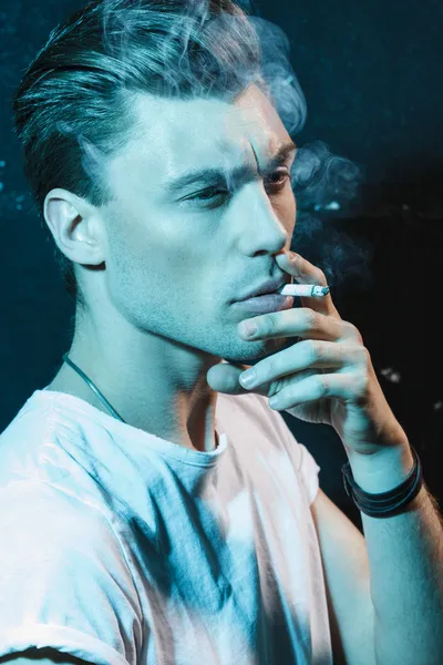 Handsome young man smoking cigarette — Stock Photo, Image