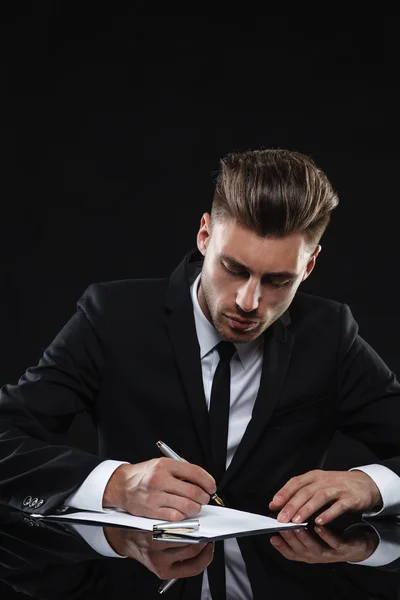 Hombre joven guapo en traje sobre fondo oscuro —  Fotos de Stock