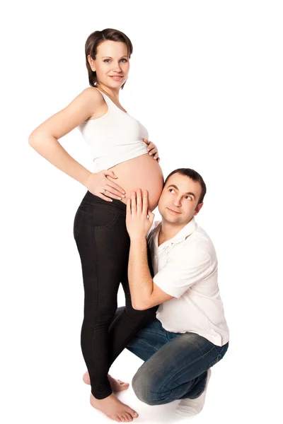 Glücklicher zukünftiger Papa, der auf den Bauch seiner schwangeren Frau hört — Stockfoto