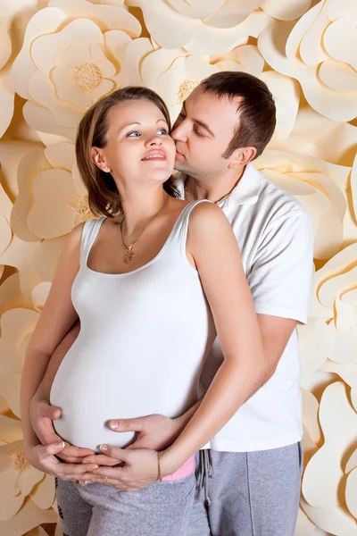 Feliz e jovem casal grávida abraçando — Fotografia de Stock