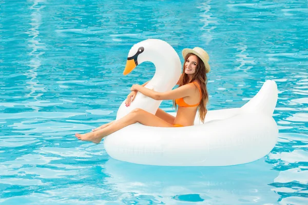Young Girl Orange Bathing Suit Swims Pool Inflatable White Swan Stockbild