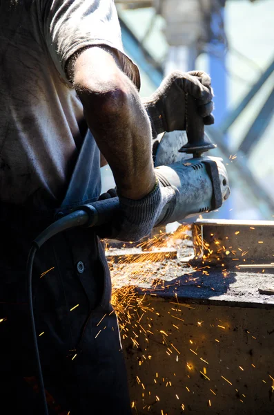 Worker grinding a metal plate. — Stock Photo, Image