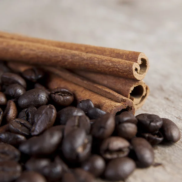 Coffee beans and cinnamon on wooden table — Stock Photo, Image