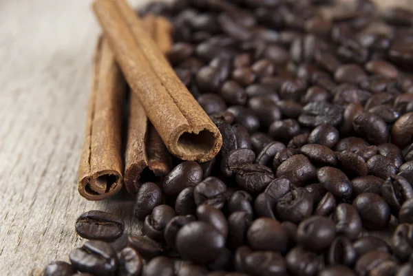 Coffee beans and cinnamon on wooden table — Stock Photo, Image