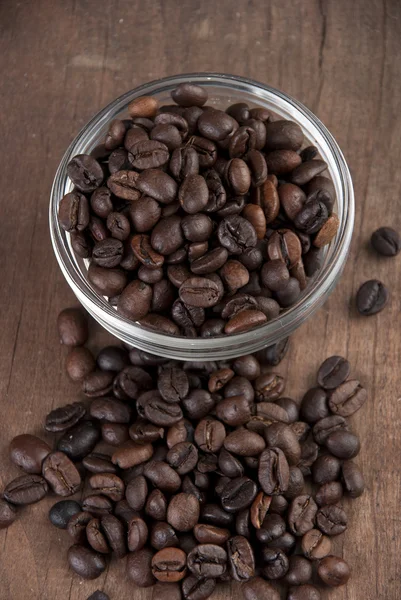 Close up of coffee beans on old wooden able — Stock Photo, Image