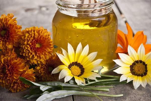 Frasco de mel com flores diferentes — Fotografia de Stock