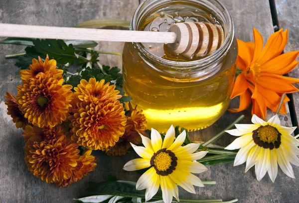 Frasco de mel com flores diferentes — Fotografia de Stock