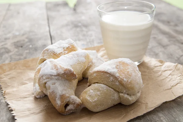 Lait et petits pains sucrés au sucre sur fond de bois — Photo