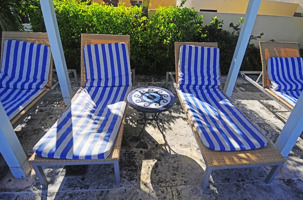 Vue des chaises longues rayées disposées près de la piscine — Photo