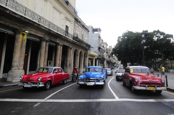 Tres viejos coches americanos en la intersección Fotos de stock libres de derechos