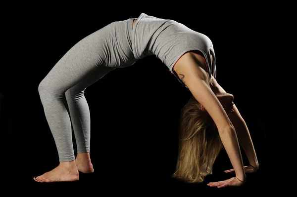 Hermosa joven en gran forma practicando yoga —  Fotos de Stock