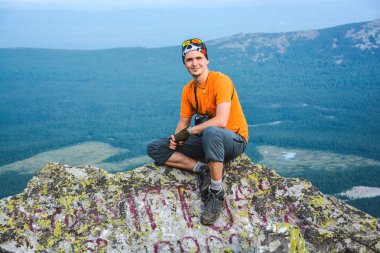 kayanın üzerinde otururken yakışıklı genç