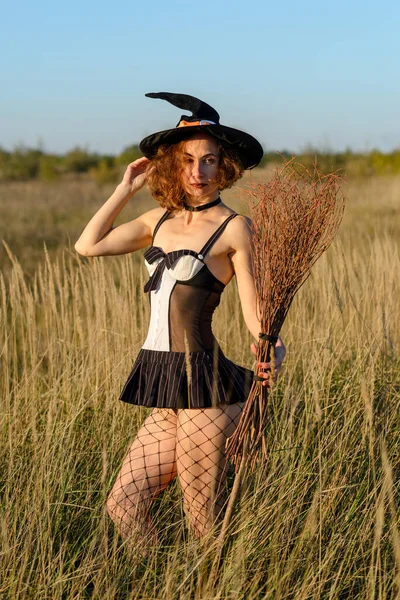 Cadı Şapkası Takan Tarlada Süpürgesi Olan Seksi Genç Bir Kadın — Stok fotoğraf