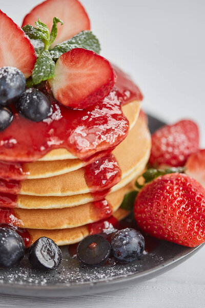Pancakes close up, with fresh strawberry, blueberries, mint and jam Stock Photo