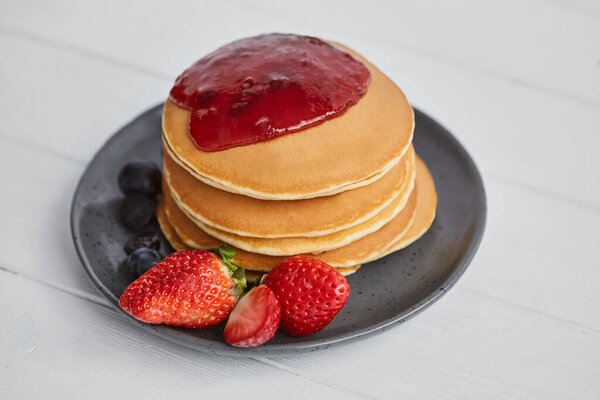 Pancakes close up, with fresh strawberry, blueberries, mint and jam Royalty Free Stock Images