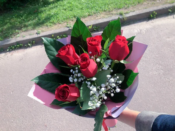Ramo de rosas rojas en primer plano en la calle —  Fotos de Stock