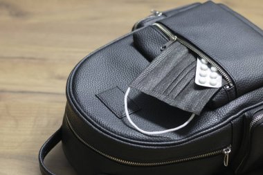 Women's backpack bag and medical mask with medicines in an open pocket