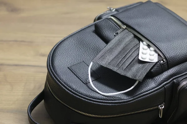 Women's backpack bag and medical mask with medicines in an open pocket