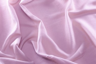 Delicate pink silk draped background, flowing ribbed fabric.