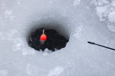 Buzun içindeki bir delikte, bir şamandıraya yakın çekim. Kışın balık kokusu