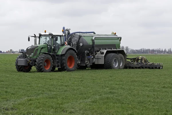 Traktor spritzt Gülle in Wiese — Stockfoto