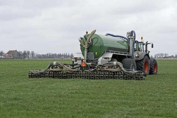 Traktor befecskendez a folyékony trágya a réten — Stock Fotó