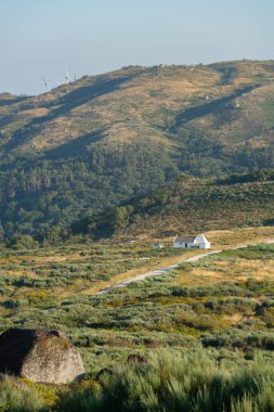 White house in the middle of mountain green landscape on a summer day in Fafe, Portugal