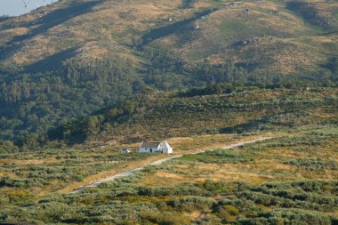 White house in the middle of mountain green landscape on a summer day in Fafe, Portugal