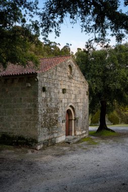 Landscape view of Sao Pedro chapel with trees and boulders in Monsanto, Portugal