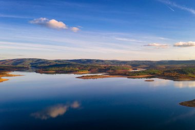 Portekiz 'in Sabugal kentindeki gökyüzü suyuna mükemmel yansıyan baraj gölünün insansız hava görüntüsü.
