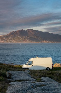 İspanya 'nın Galiza kentinde yaşayan dağlı deniz manzaralı güneş panelleri olan karavan karavanı.