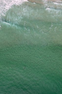 İHA üst hava görüntüsü sörfçünün üzerinde cennet turkuvaz deniz suyu dalgaları üzerinde sörf İspanya 'da