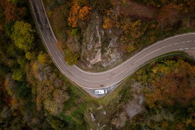 Sonbahar boyunca bir dağ manzarasında güneş panelleri olan bir karavanın insansız hava aracı görüntüsü