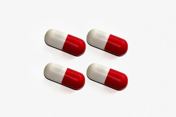 Comprimido vermelho e branco fundo isolado no branco — Fotografia de Stock