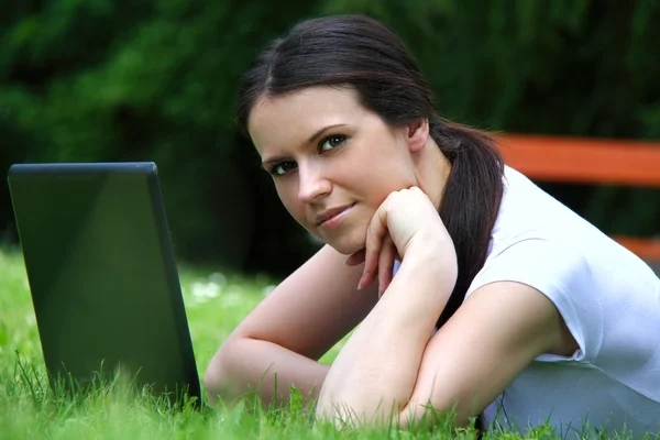 Beautiful young student using laptop on grass Stock Image