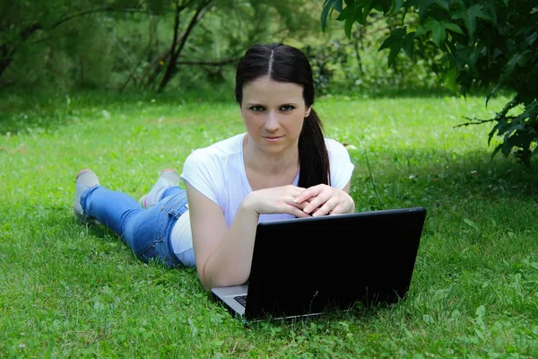 美丽年轻的学生在草坪上使用便携式计算机 — 图库照片