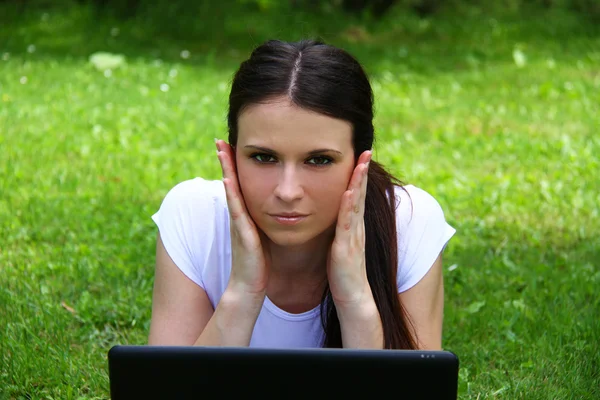 Hermosa joven estudiante usando el ordenador portátil en la hierba —  Fotos de Stock