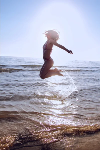 Jovencita saltando de un agua — Foto de Stock