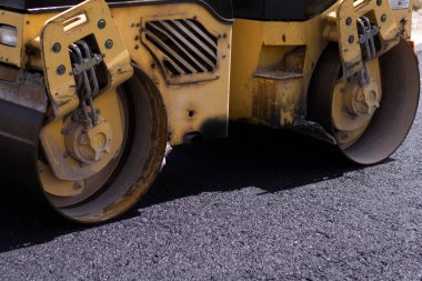 Şehir yolu asfaltlaması işe yarıyor. Asfalt kaldırım. Paver makinesi ve yol silindiri. Yeni yol yapımı.