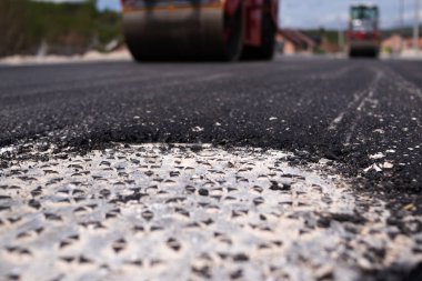 Şehir yolu asfaltlaması işe yarıyor. Asfalt kaldırım. Paver makinesi ve yol silindiri. Yeni yol yapımı.