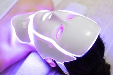 LED maskeli yenileme tedavisi genç bir kadına uygulanır.