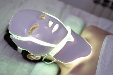 LED maskeli yenileme tedavisi genç bir kadına uygulanır.