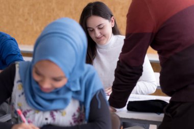 Modern üniversite sınıfında teknik planlama konusunda profesörle işbirliği yapan yetenekli bir grup uluslararası öğrenci