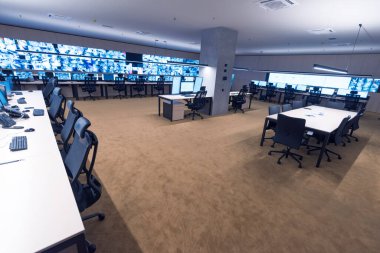Güvenlik görevlisi gözetleme odasındaki modern güvenlik kameralarını izliyor.