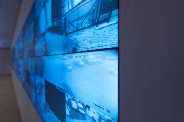 Güvenlik görevlisi gözetleme odasındaki modern güvenlik kameralarını izliyor.