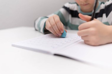 Okullu çocuk evde alfabe yazma alıştırması yapıyor. Çocuk çocuk yazıyor. Ev ödevi.