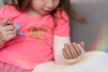 Kızın sol kolu kırık, koluna güzel bir resim çizmiş.