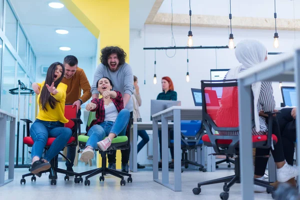 Genç iş adamları ofiste sandalyeye biniyor.